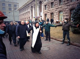 Un sacerdote escolta a un grupo de detenidos <br>por los enfrentamientos en la plaza del Maidan. 