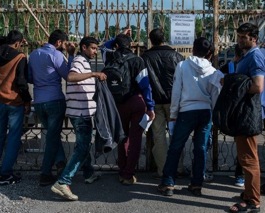 Un grupo de refugiados ante la verja.