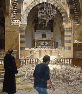 El padre Ibrahim Alsabagh entre los escombros <br>de una iglesia católica en Alepo.