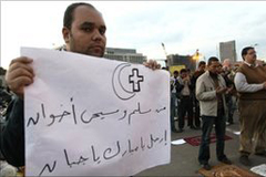 Un cristiano copto con un cartel que dice: “Musulmanes y cristianos somos hermanos, vete Mubarak, eres un cobarde”.